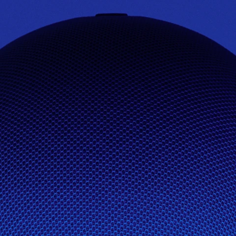 Close-up of a textured blue speaker cover against a dark blue background.